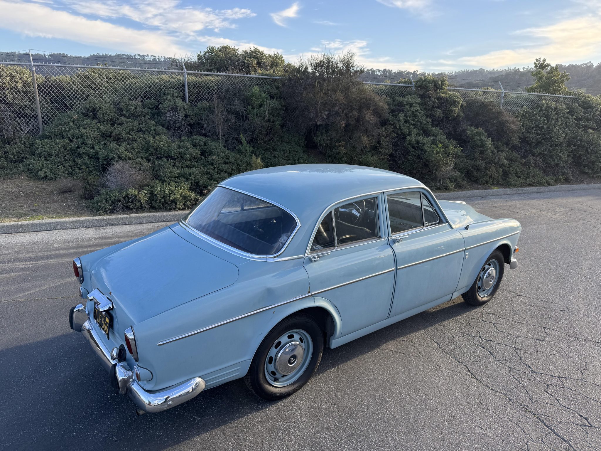 Rear three-quarter view of the light blue Volvo